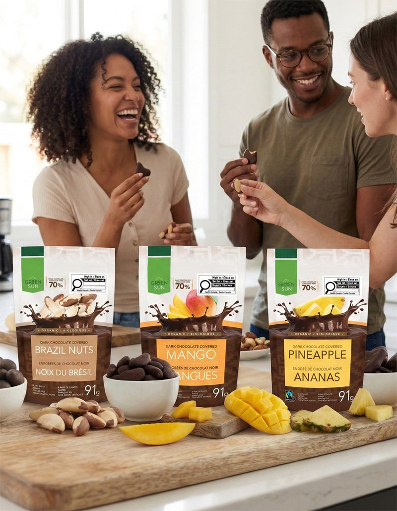 Friends enjoying Green Sun dark chocolate fruit snacks including mango, pineapple and Brazil nuts.