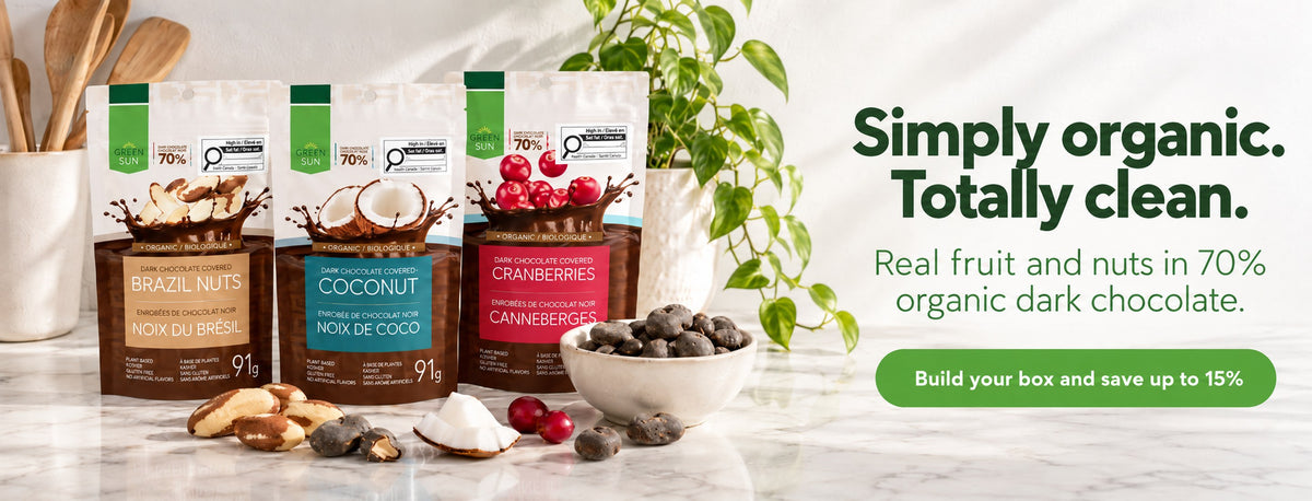 Simply organic, totally clean: Green Sun Brazil nut, coconut and cranberry pouches on a marble kitchen counter with a bowl of dark chocolate covered snacks